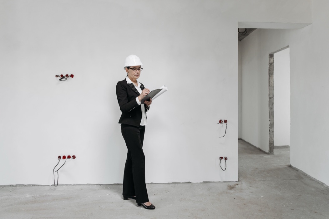 Profissional em obra revisando anotações técnicas antes do próximo passo